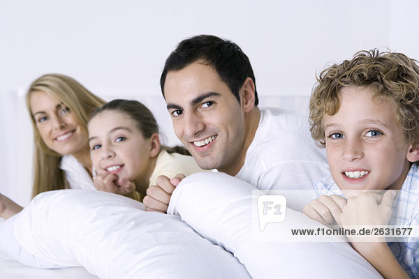 Portrait of family lying in bed together