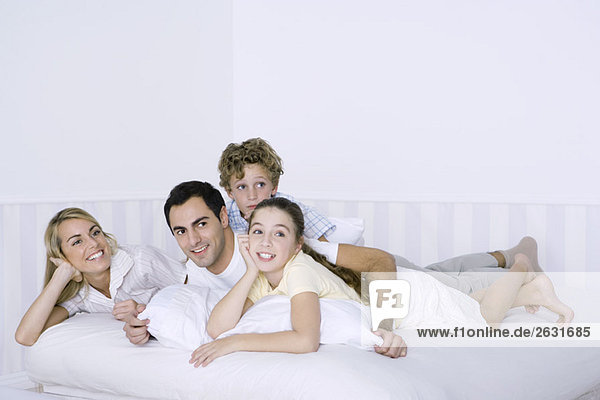 Parents and two children lying in bed together