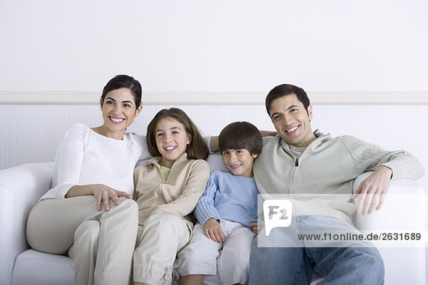 Family sitting together on sofa  smiling