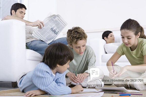 Three children sitting on the floor  coloring  parents reading in background