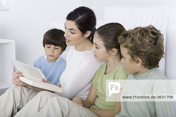 Frau liest ihren Kindern die Geschichte vor