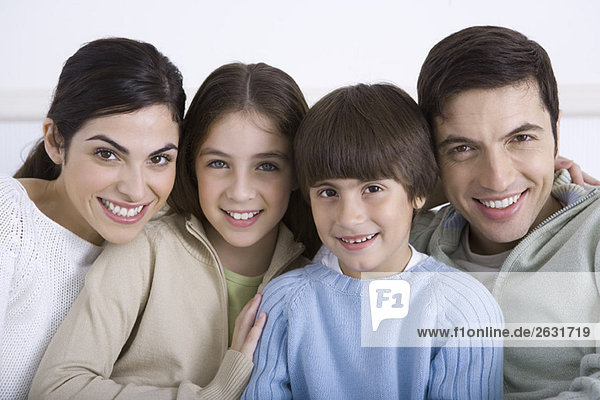 Family cheek to cheek  smiling at camera  portrait