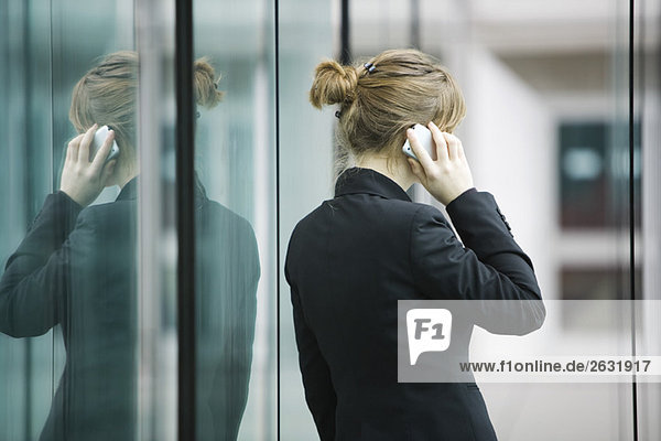 Businesswoman using cell phone  rear view