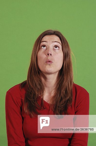 Überraschte Frau schaut nach oben