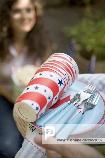 Hände halten Picknickgeschirr für den 4th of July