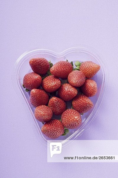 Frische Erdbeeren in herzförmiger Plastikschale