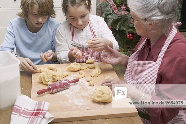 Grossmutter und Enkel bereiten Vanillekipferl zu