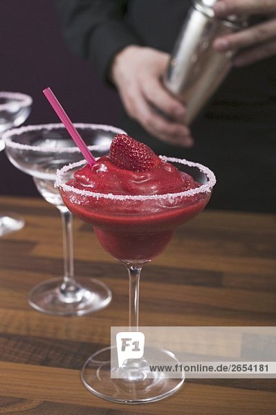 Strawberry Daiquiri in glass  bartender in background