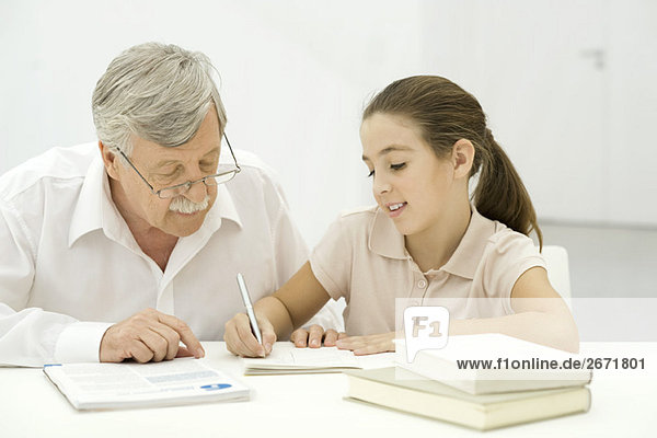 Grandfather helping granddaughter with homework