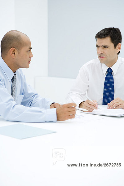 Two businessmen sitting at table having meeting