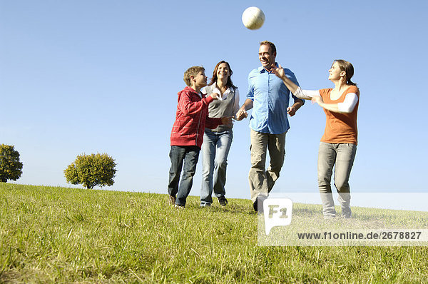 Familie Volleyballspielen im Feld