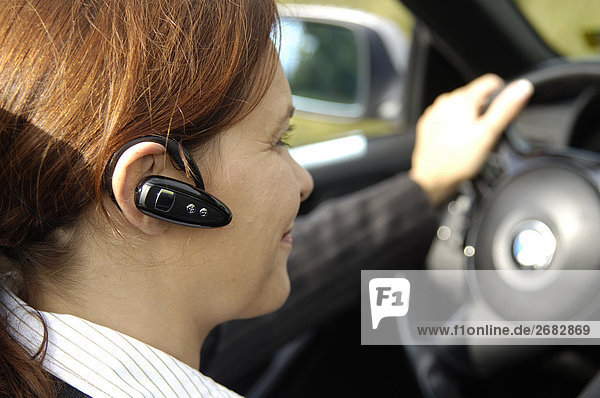 Nahaufnahme Frau mit Bluetooth während der Fahrt Auto