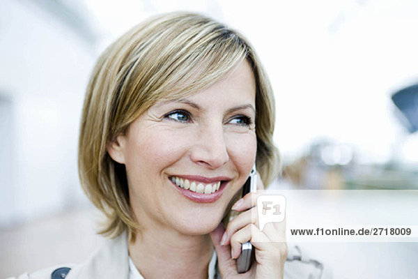 Frau lächelt und spricht am Handy