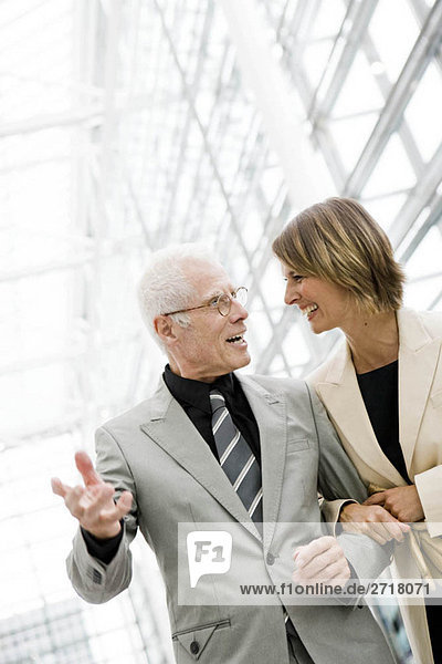 Älterer Mann im Gespräch mit jüngerer Frau