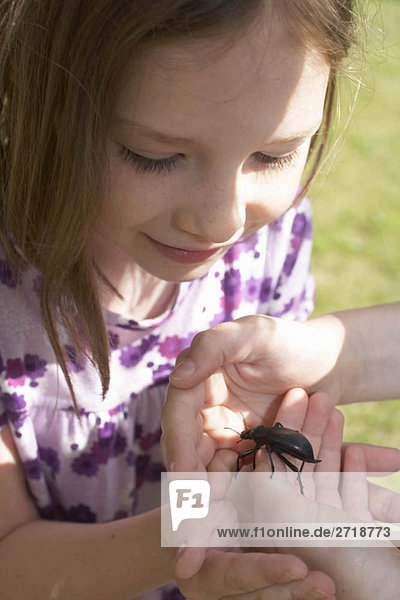 Young girl looking at an insect
