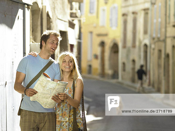 Couple studying map in street