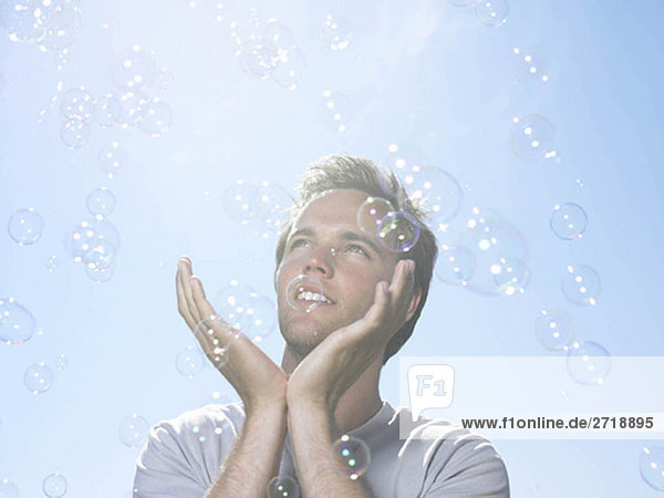 Man in sun holding bubbles