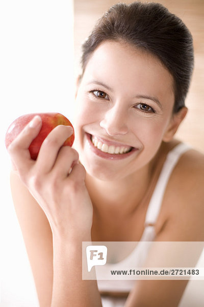 Young woman holding an apple  smiling