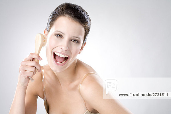 Young woman using peeling brush  laughing  close up