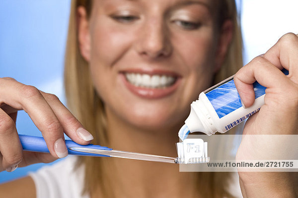 Junge Frau mit Zahnpasta auf der Bürste  Portrait