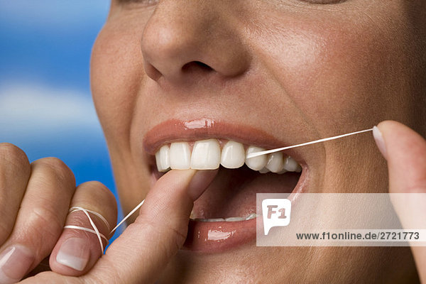 Young woman flossing her teeth  close-up