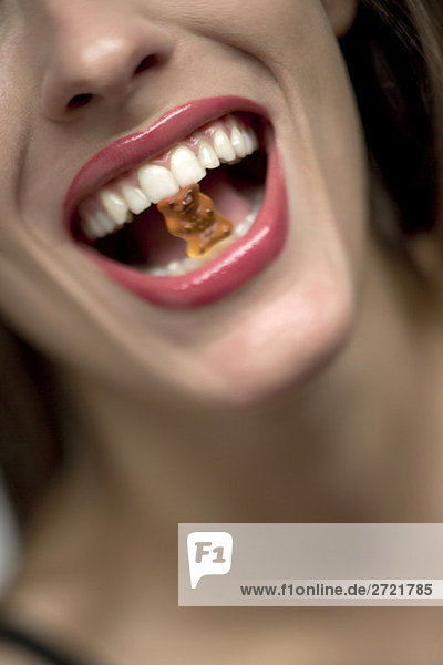 Young woman with gummi bear in mouth  portrait