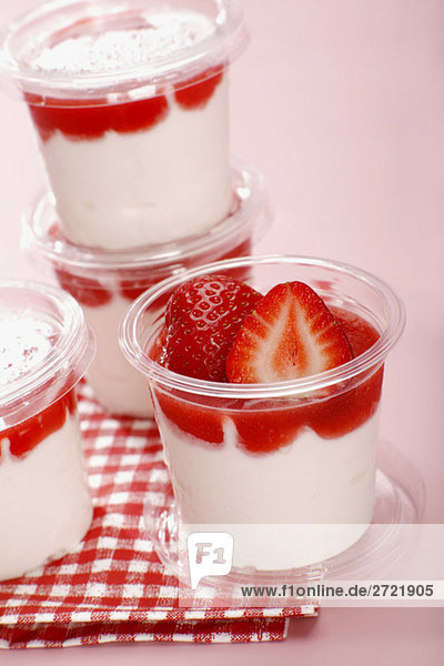 Geschichtetes Erdbeer-Joghurt-Dessert in Plastikbechern