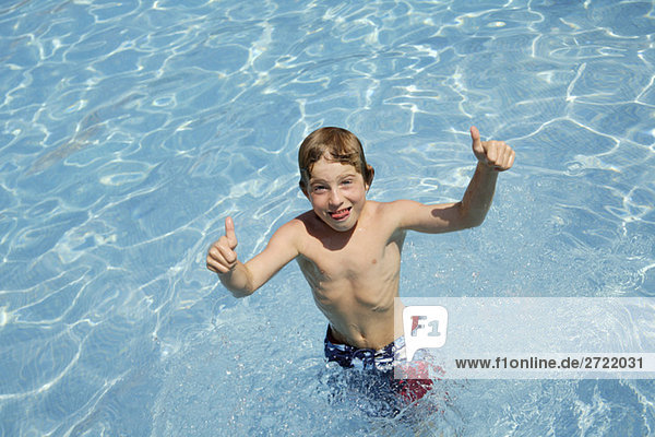 Junge (10-11)  der im Schwimmbad herumalbert