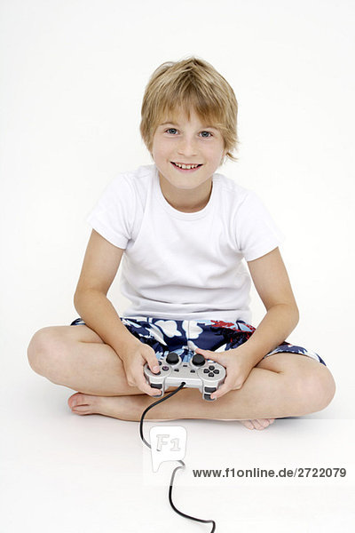 Junge (10-11) spielt Computerspiel  lächelnd  Portrait