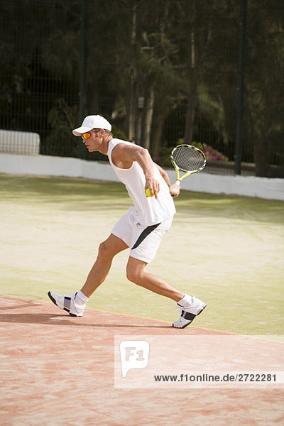 Man playing tennis  side view