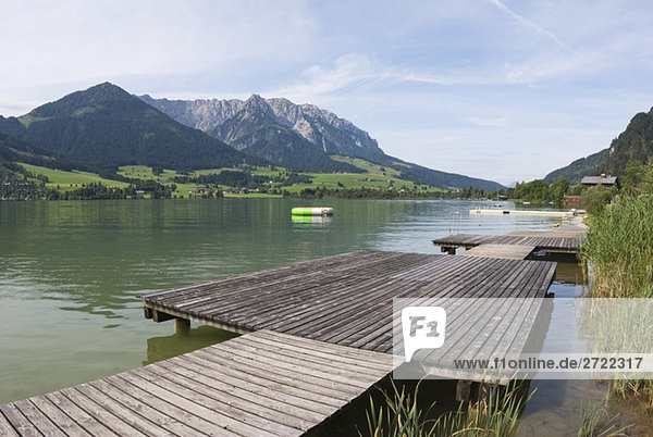 Austria  Tyrol  Walchsee  Boardwalk on waterfront  mountains in background