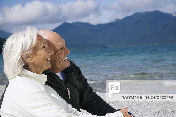 Germany  Bavaria  Walchensee  Senior couple relaxing on lakeshore