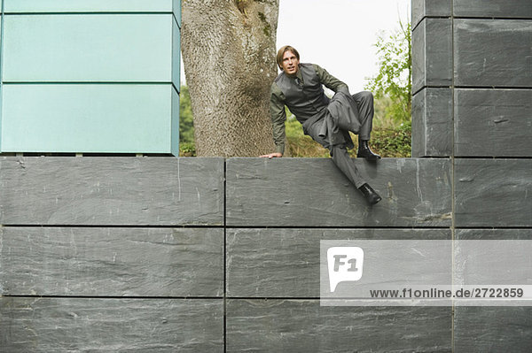 Germany  businessman climbing on wall