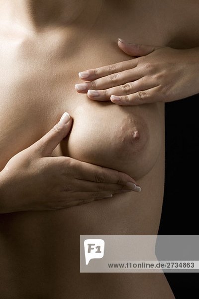 A woman examining her breast