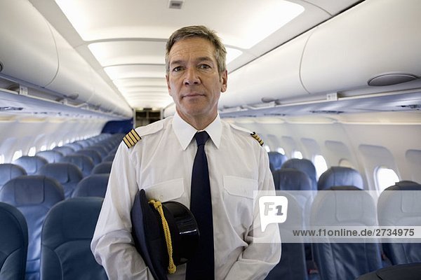 Ein Pilot  der in der Kabine eines Flugzeugs steht.