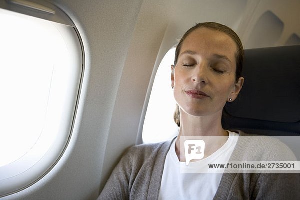 Eine Frau  die in einem Flugzeug schläft.