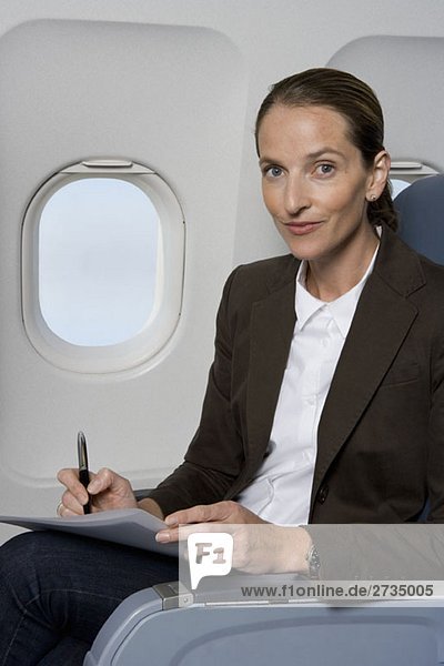 Eine Geschäftsfrau  die in einem Flugzeug arbeitet.