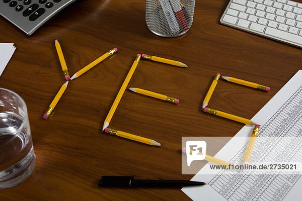 Bleistifte auf einem Schreibtisch  die so angeordnet sind  dass sie Ja buchstabieren.