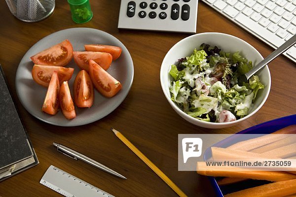 Ein Schreibtisch mit Büromaterial und gesunder Ernährung