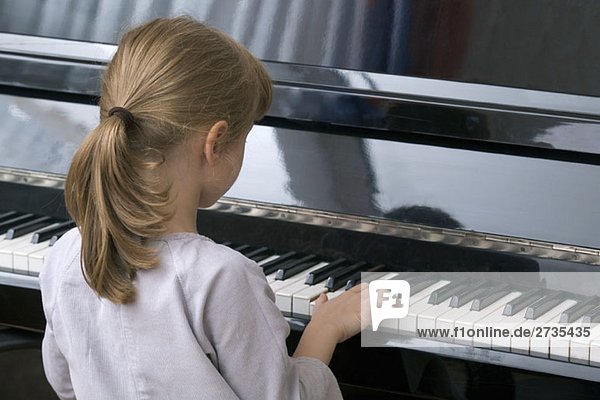 A young girl playing piano