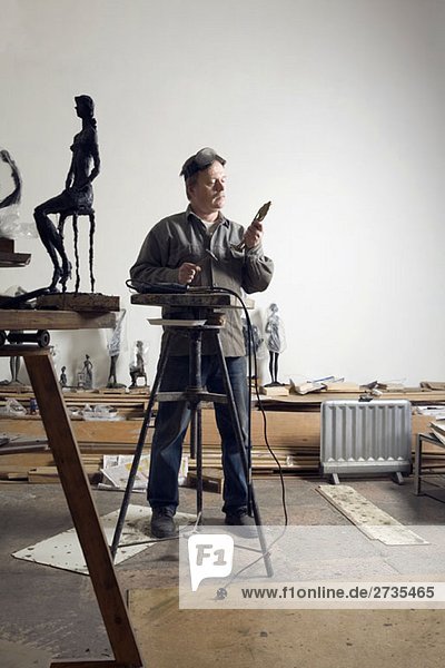A sculptor working in an art studio