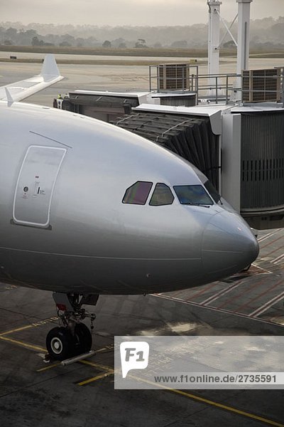 An airplane parked next to a passenger boarding bridge