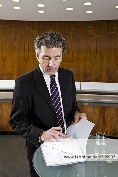 A businessman standing and looking at a document