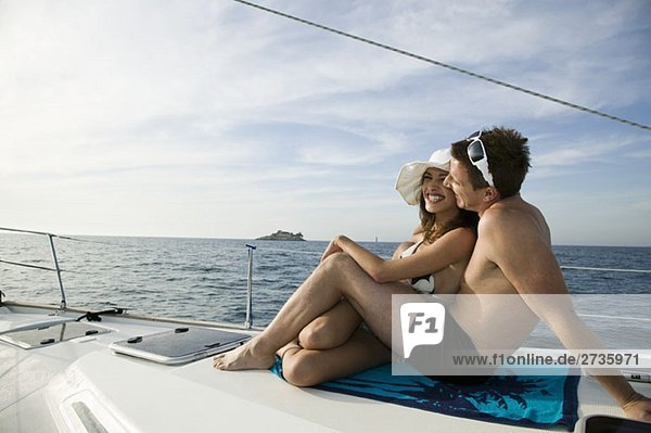 Ein Paar beim gemeinsamen Sonnenbaden auf einer Yacht