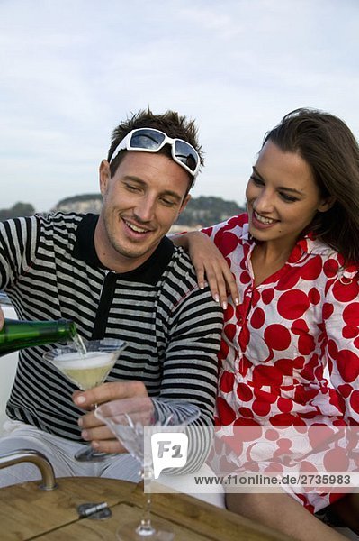 Ein Paar genießt Champagner auf einer Yacht