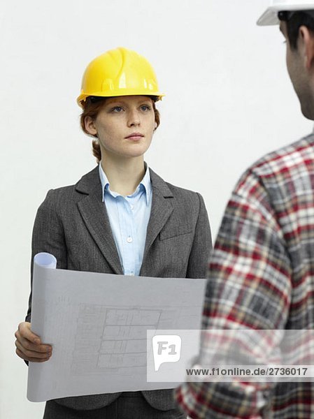 An architect speaking with a construction worker