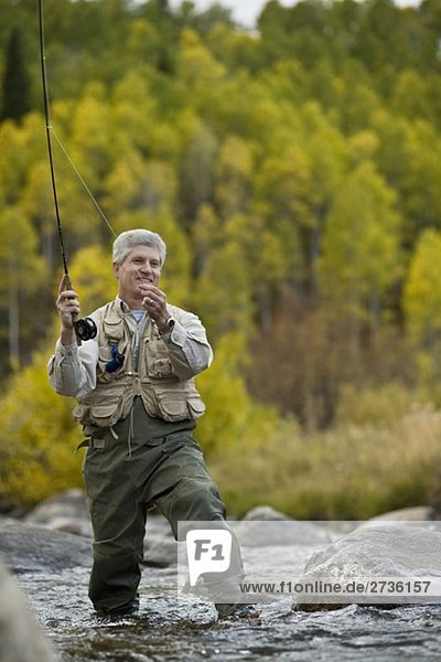 Ein Mann beim Fliegenfischen in einem Fluss