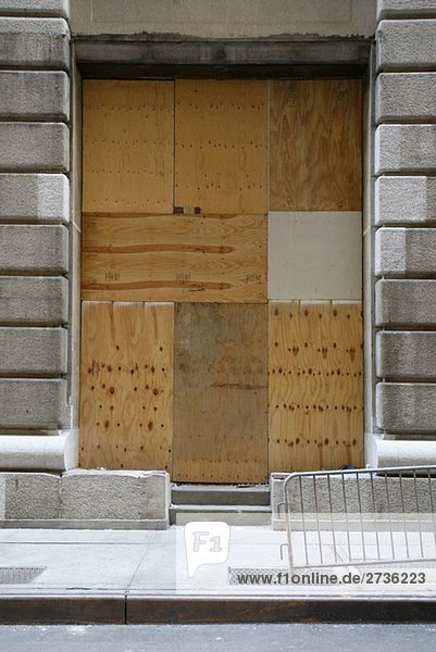 Ein Eingang zu einem mit Holz versperrten Gebäude