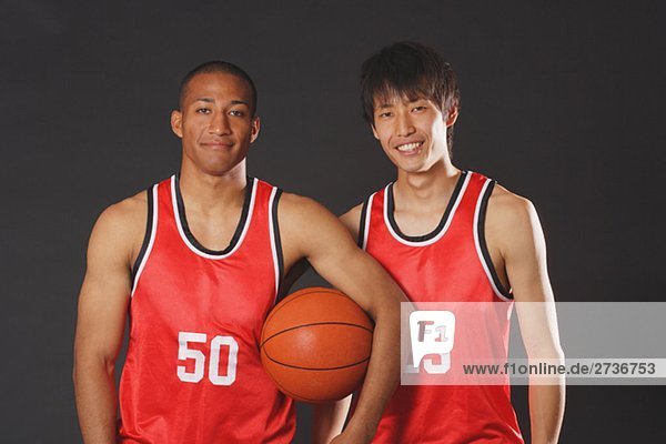 Lächelnd junge Männer posieren mit basketball