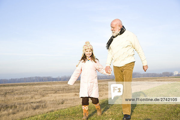 Mädchen mit ihrem Großvater zu Fuß